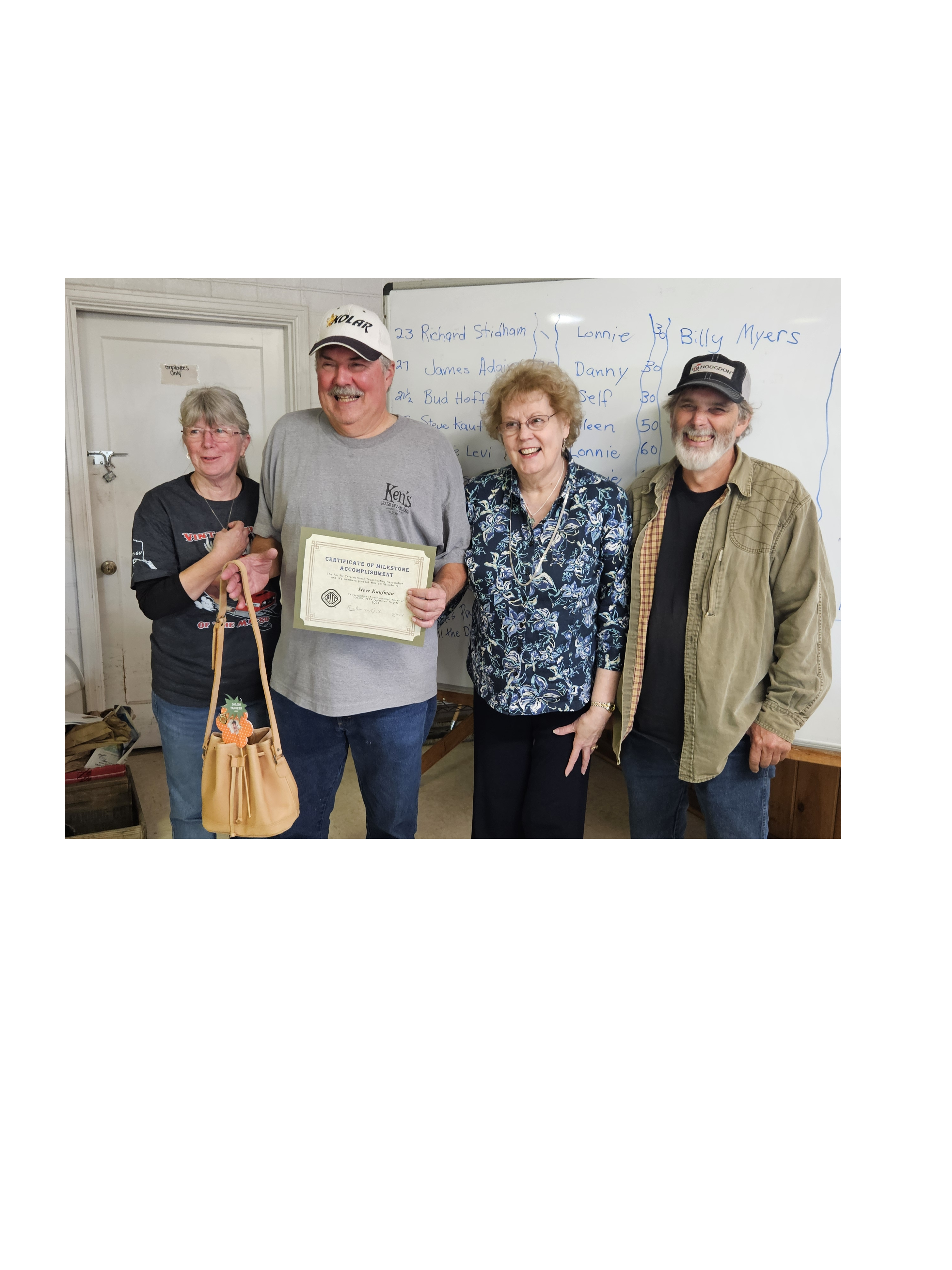 Sue and James (ends) presenting Steven and Judy 300,000 (center) milestone award